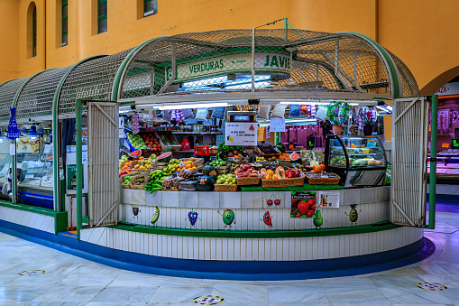Pamplona, Spain - June 22 2021: Produce vendor in a covered shopping stand at the central market Mercado de Santo Domingo in the old town, Casco Viejo