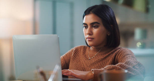 istock Shot of a young woman using a laptop while studying at home 1352185159