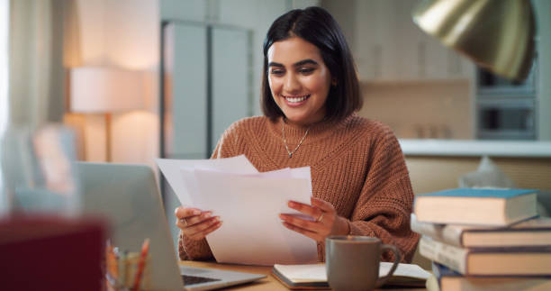 istock Shot of a young woman going through paperwork while studying at home 1352185848