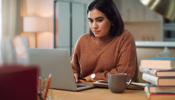 istock Shot of a young woman using a laptop while studying at home 1352185853