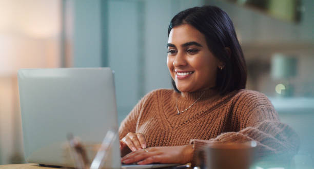 istock Shot of a young woman using a laptop while studying at home 1352185859