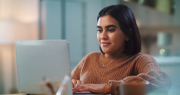 istock Shot of a young woman using a laptop while studying at home 1352185861