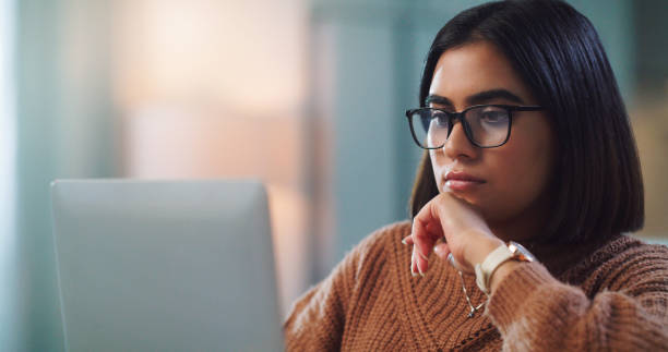 istock Shot of a young woman using a laptop while studying at home 1352185863