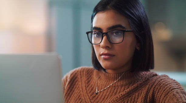 istock Shot of a young woman using a laptop while studying at home 1352185867