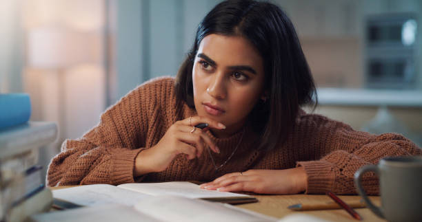 istock Shot of a young woman looking thoughtful while studying at home 1352185965