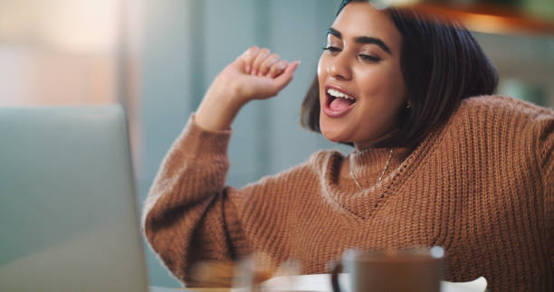 istock Shot of a young woman cheering while using a laptop to study at home 1352185977