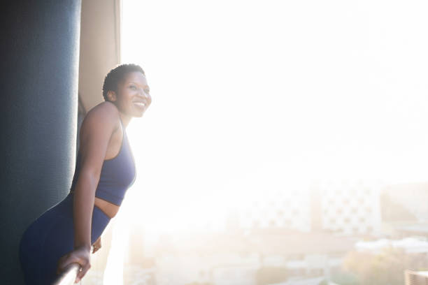 istock Young woman in exercise clothes on balcony at sunrise 1352188949