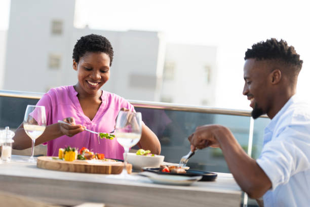 istock Young couple eating outdoors at rooftop restaurant 1352188974