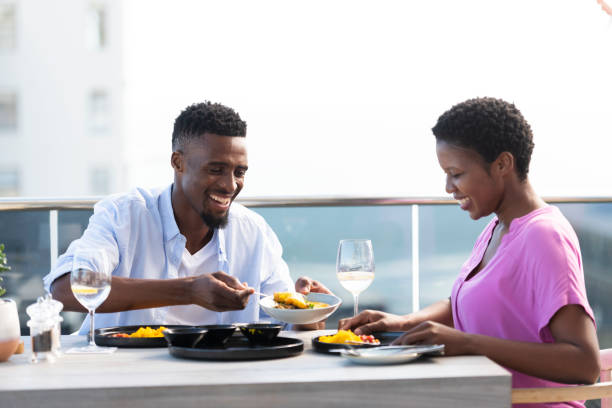 istock Young man serves food for his girlfriend at a rooftop restaurant 1352188976