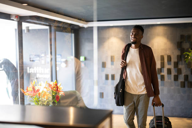 istock Young man arriving at hotel reception 1352189102