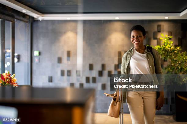 Confident Young Woman Arriving In Hotel Reception Stock Photo - Download Image Now - Hotel, Hotel Reception, Travel