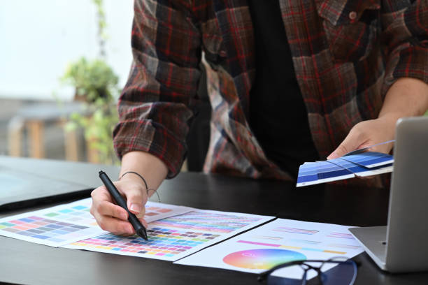 istock Creative designer holding digital tablet and working with color palette at office desk. 1352190094