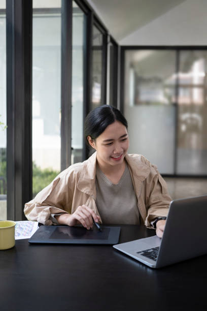 istock Smiling young female designer working at creative office. 1352190220