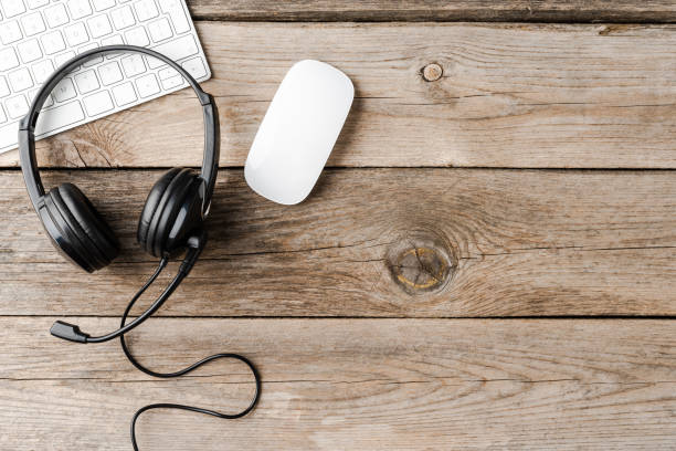 istock Helpdesk headset and computer on wooden desktop. Call center 1352192329