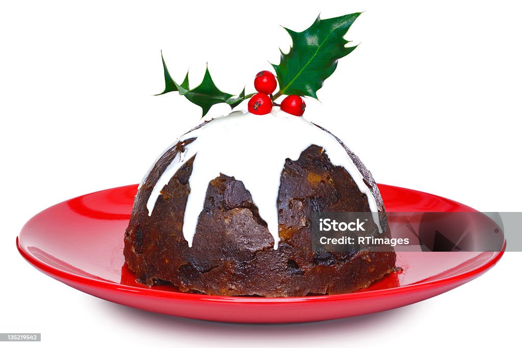 Christmas pudding isolated Photo of a steamed Christmas pudding with cream and holly on top isolated on a white background. Slight motion blur on the cream. Christmas Pudding Stock Photo