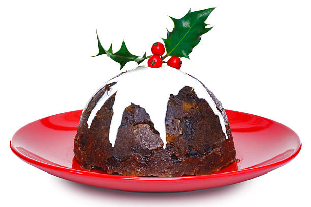 Christmas pudding isolated Photo of a steamed Christmas pudding with cream and holly on top isolated on a white background. Slight motion blur on the cream. christmas pudding stock pictures, royalty-free photos & images