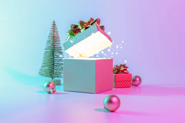 istock Neon Christmas winter background. Open xmas gift box with shine lights, minimal tree. Holiday decoration bauble ball on neon abstract gradient backdrop. Happy new year copy space. 1352196139