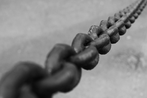 Old black chain, close up black and white photo with selective soft focus