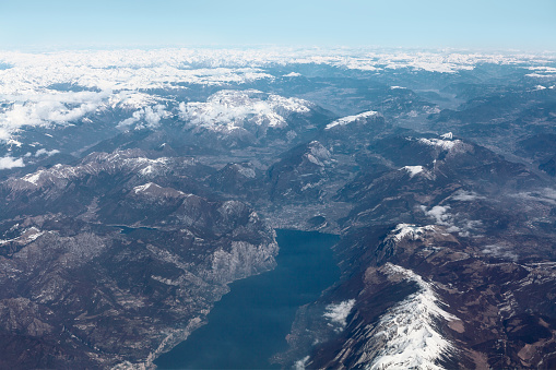 Lake Garda and Alps view from above . Aerial view of snowy mountain an lake . largest lake in Italy . Riva del Garda italian settlement