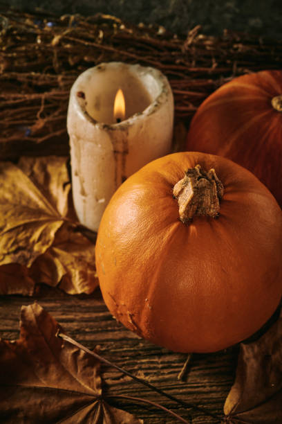 istock Autumn pumpkins and a candle on a wooden background 1352201904