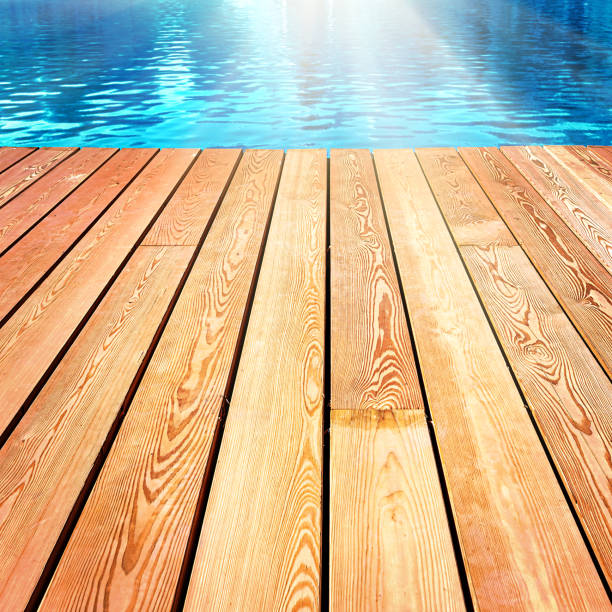 istock Empty white wood table top on blur abstract blue sea background with sunlight as product display and mockup 1352208565