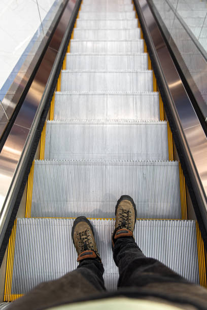 istock Male feet on the escalator, top view. 1352214023