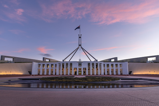 a sunset shot of federal parliament house at canberra in the act, australia