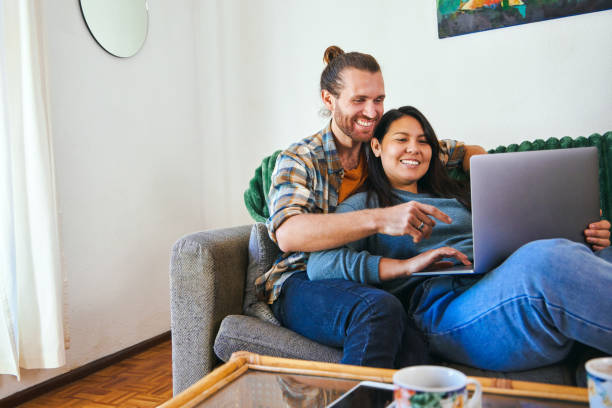 istock Shot of a young couple relaxing together while using their laptop 1352214605