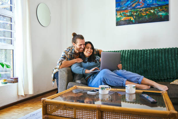istock Shot of a young couple relaxing together while using their laptop 1352214610