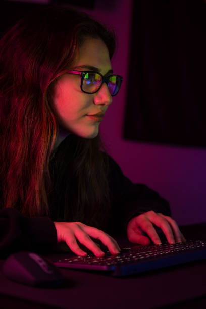 istock Young girl playing computer game at night 1352215256
