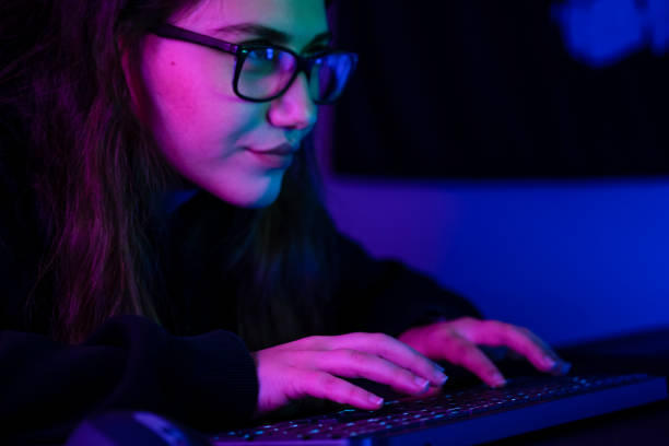 istock Young girl playing computer game at night 1352215591