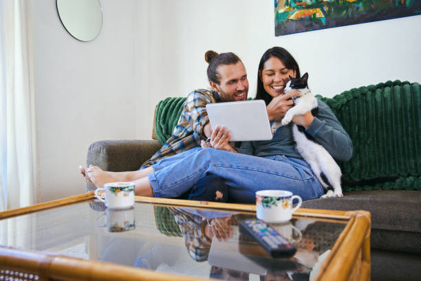 istock Shot of a young couple using their digital tablet while cuddling their pet car 1352216544
