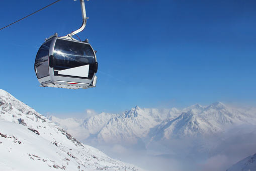 Active lifestyle, Vital female snow skier skiing, enjoying on sunny ski resorts. Skiing carving at high speed. Ski lift in the backgroundItalian. Alps  ski area. Ski resort Livigno. italy, Europe.