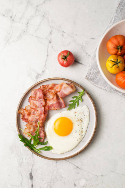 영어 아침 식사. 달걀과 튀긴 베이컨. 토마토와 컵. 대리석 테이블에서 조식을 제공합니다. 달걀 후라이. - eggs breakfast bacon fried egg 뉴스 사진 �이미지