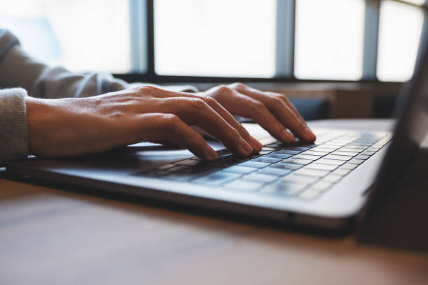 una donna che lavora e digita sulla tastiera del computer portatile sul tavolo - touchpad laptop computer software human finger foto e immagini stock