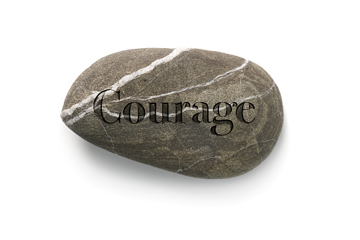COURAGE - engraved stone rock with the word courage on white background
