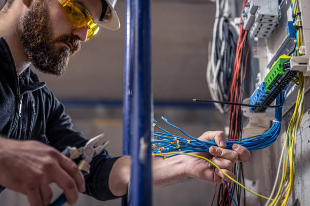 istock A male electrician works in a switchboard with an electrical connecting cable. 1352218993