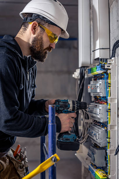 istock A male electrician works in a switchboard with an electrical connecting cable. 1352219002