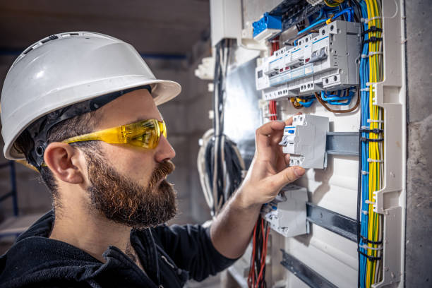 istock A male electrician works in a switchboard with an electrical connecting cable. 1352219008