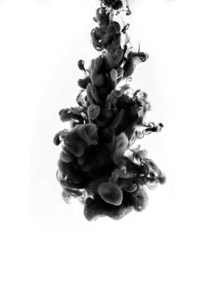 istock Black ink falling into the water with the background isolated on white. 1352219341