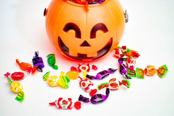 Halloween pumpkin with candies by the side, with white background.