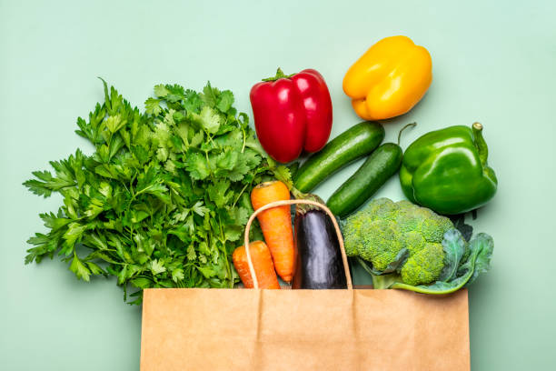 緑の背景に分離された生の有機緑色の野菜とエコフレンドリーな紙の店袋フラットレイ、トップビューゼロ廃棄物、プラスチックフリーコンセプト - cooking food lifestyles green ストックフォトと画像