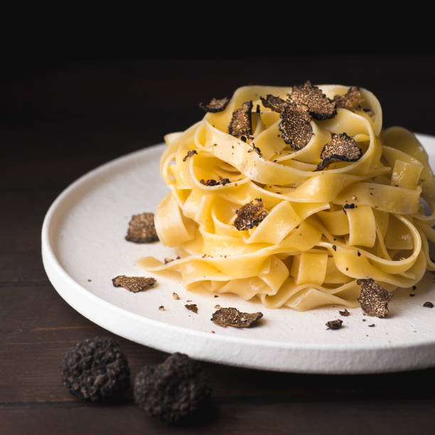 pasta tagliatelle con setas de trufa negra. tagliatelle al tartufo - receta fresca italiana de otoño con trufa negra, estilo rústico, cosecha cuadrada - truffle fotografías e imágenes de stock