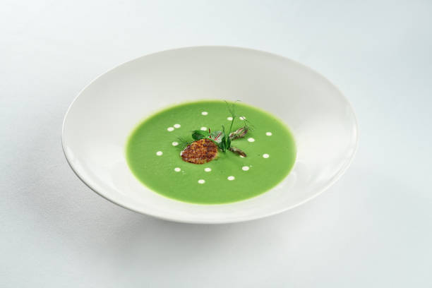 istock Cream soup from asparagus with scallop in a white plate on a white tablecloth 1352227164