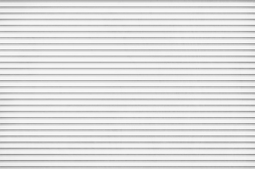 Vector illustration of striped backgrounds resembling textured corrugated paper sheet. There are thin horizontal grooved stripes all over the light gray background. Apt for use as background, wallpapers, wrapping paper.