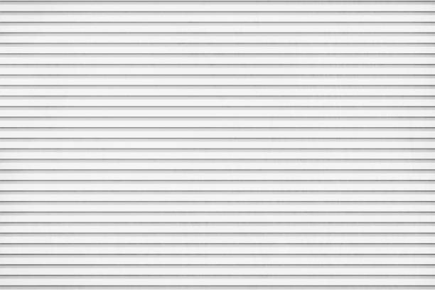 Light Grey coloured vector backgrounds like grunge textured corrugated tin or iron sheet having horizontal stripes or grooves Vector illustration of striped backgrounds resembling textured corrugated paper sheet. There are thin horizontal grooved stripes all over the light gray background. Apt for use as background, wallpapers, wrapping paper. corrugated iron stock illustrations