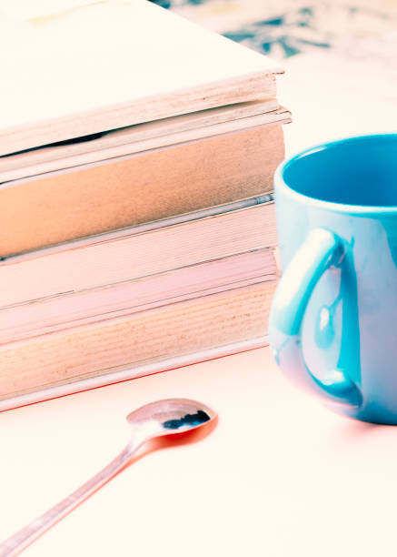 istock Literature concept. White books with a blue cup on a pink background. 1352231456