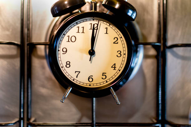 istock Cooking time concept. Black alarm clock on a kitchen stove. 1352231666