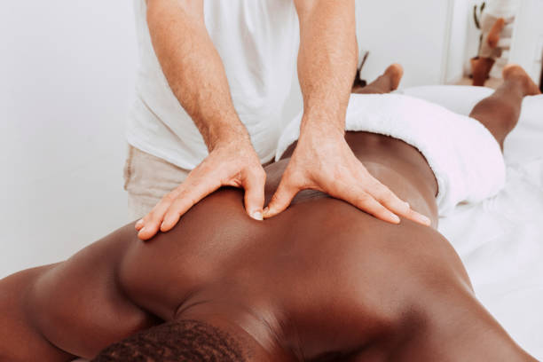 istock Therapist doing healing treatment on black man's back 1352232283