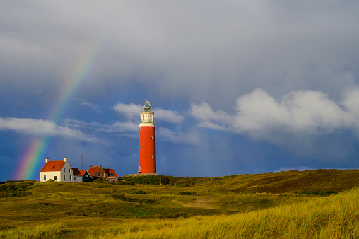 Danish coastline with endless sand beach, water waves and the village Lonstrup